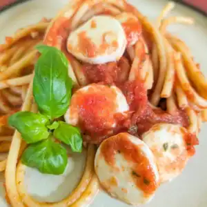 pasta on plate with fresh basil leaves