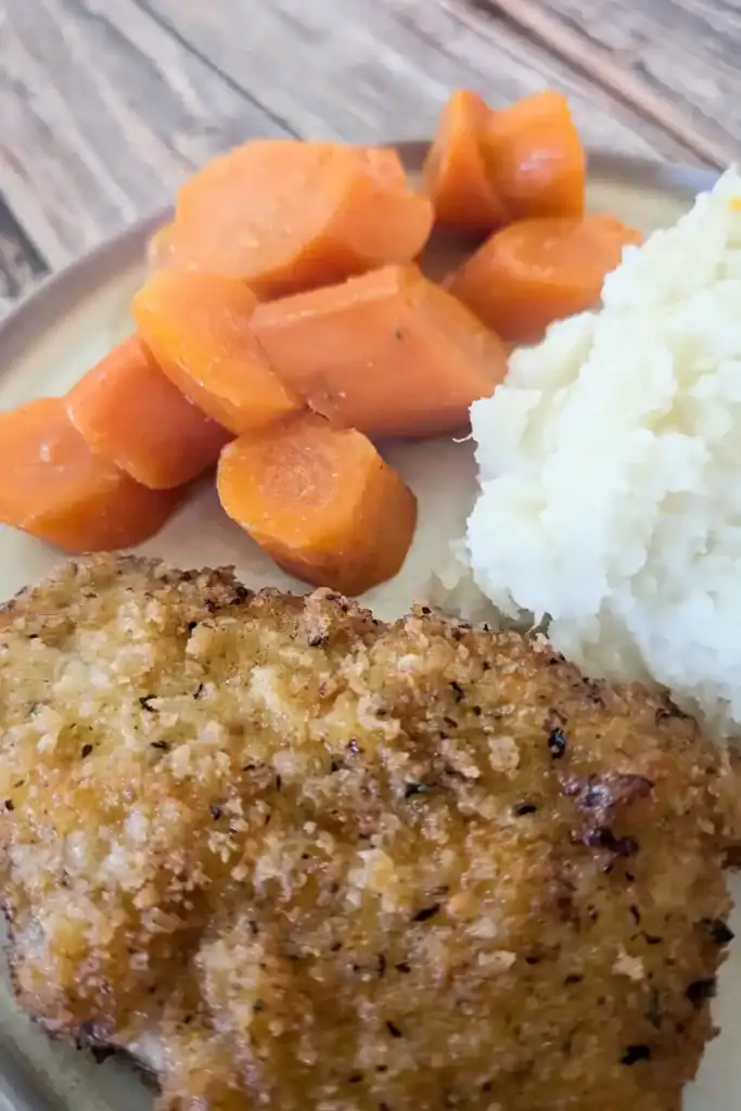 a side of honey ginger carrots with mashed potatoes and breaded pork chops