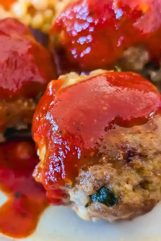 close up turkey meatball with spicy red harissa sauce