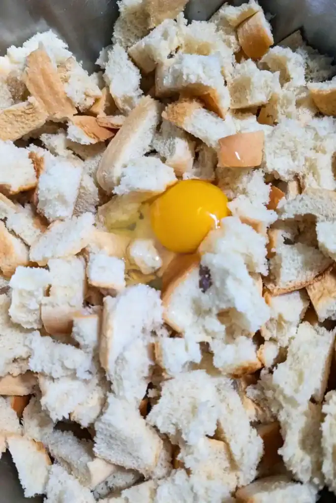 one egg added to bread for stuffing in mixing bowl