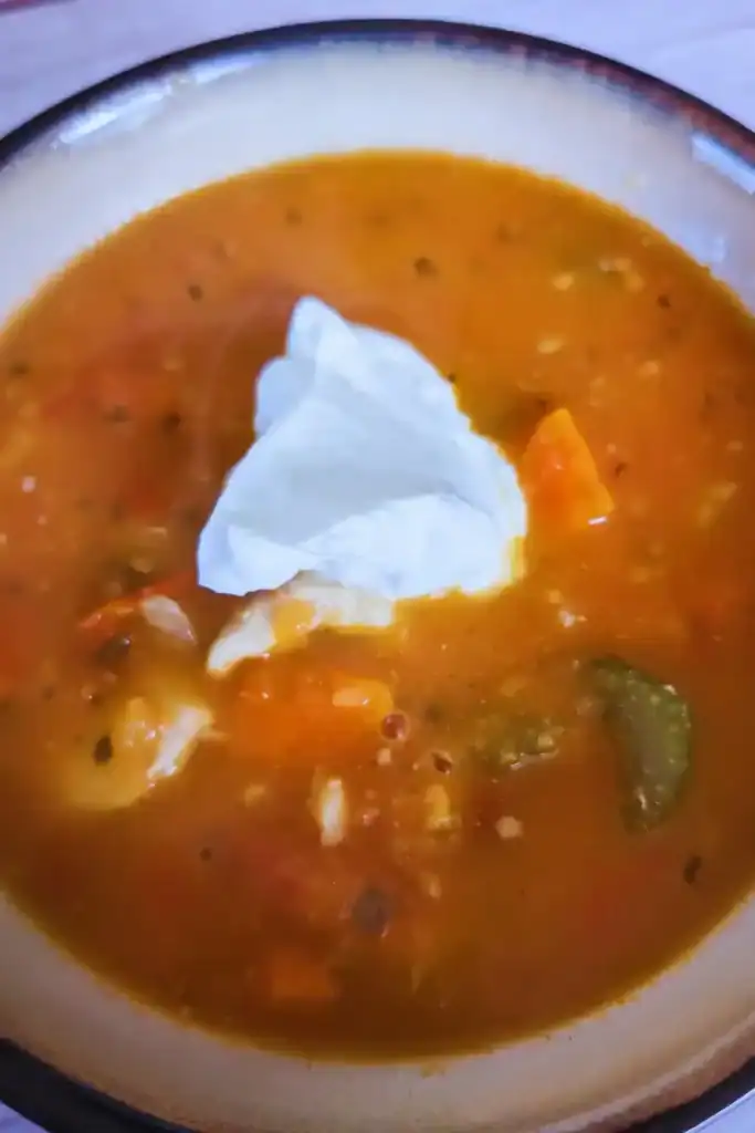 adding a dollop of sour cream to the finished soup