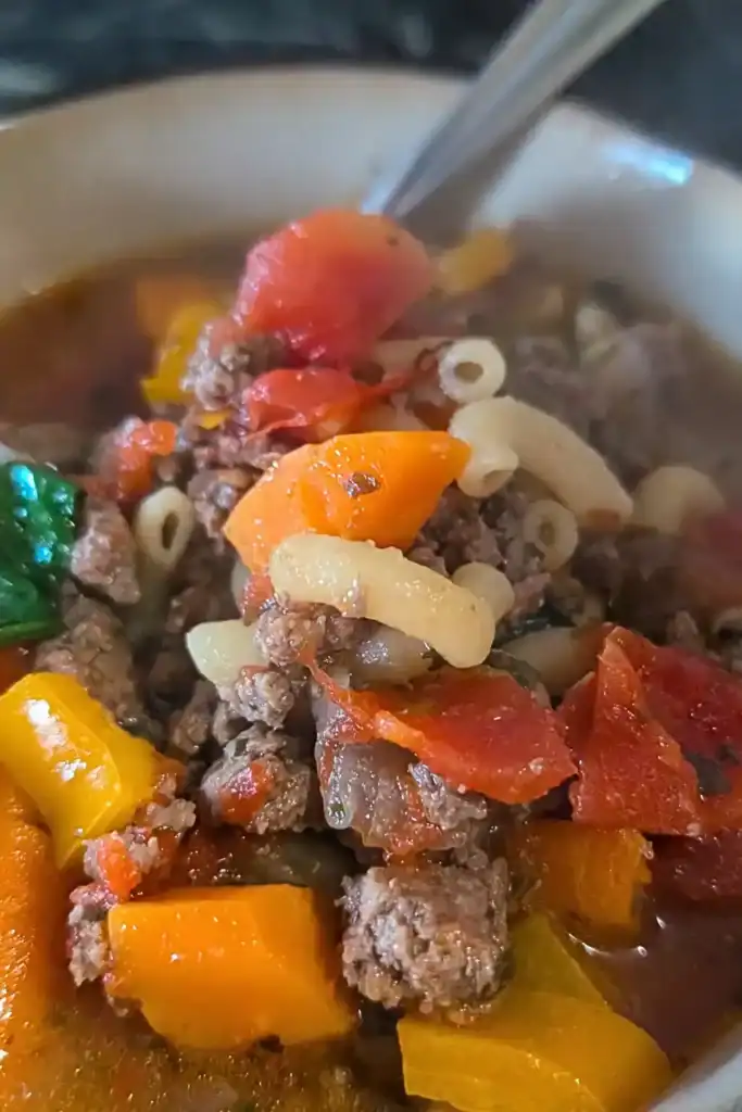 close up of hamburger soup in bowl with spoon coming out of the side of the dish