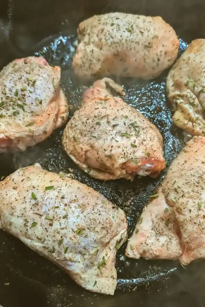 seasoned chicken thighs in cast iron skillet