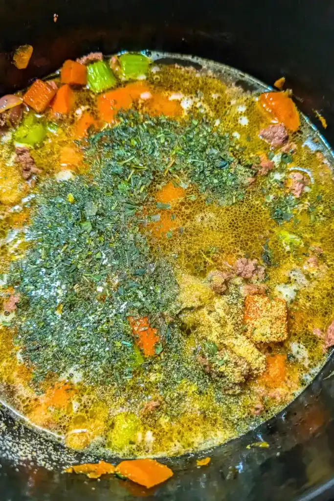 adding basil and garlic powder to the pot
