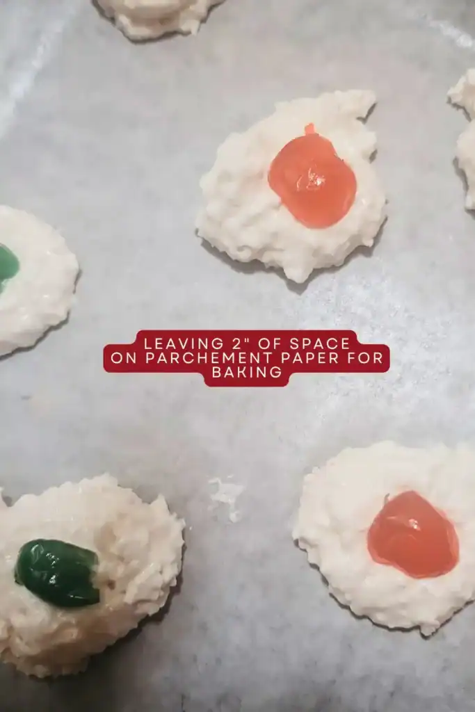 adding the coconut macaroons with candied cherry centers to baking sheet lined with parchment paper