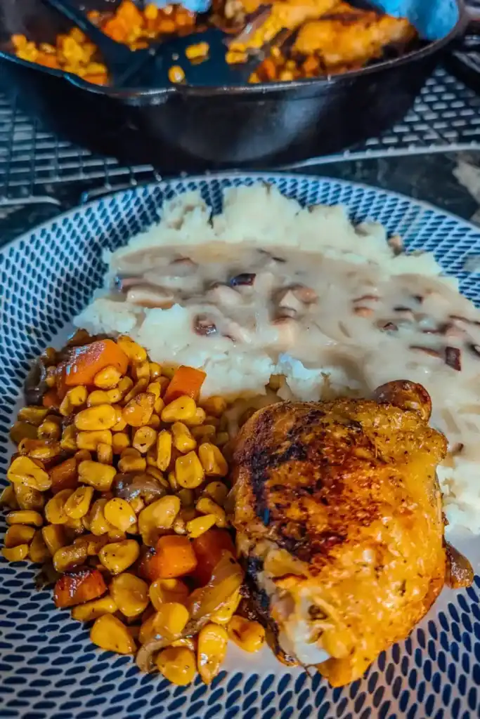 baked chicken thighs and roasted veggies served with mashed potatoes and mushroom gravy