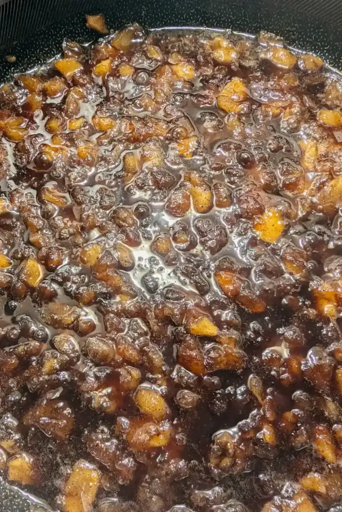 mashed apples in the sugar syrup for apple butter
