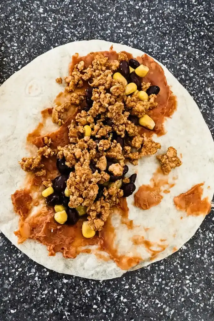 adding the meat mixture to the enchiladas