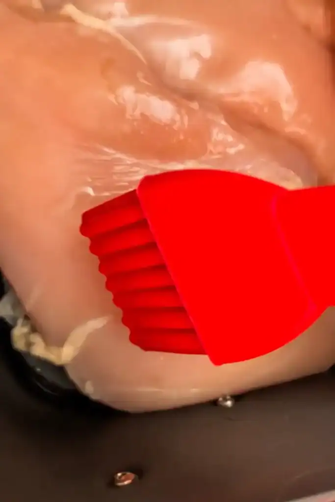brushing the chicken breast with olive oil