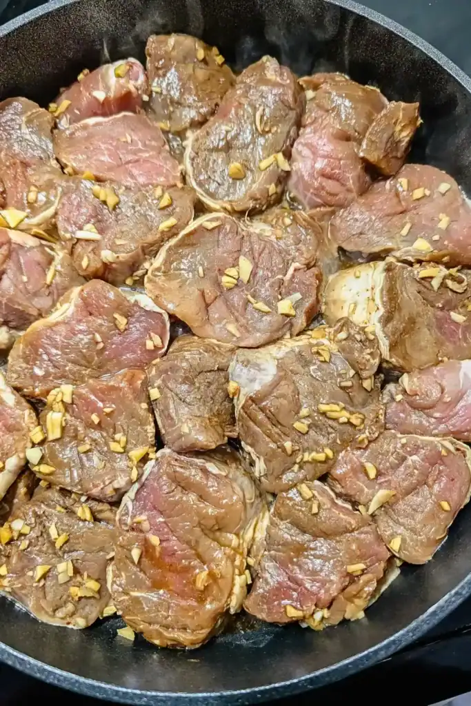 spreading marinated meat in hot frying pan