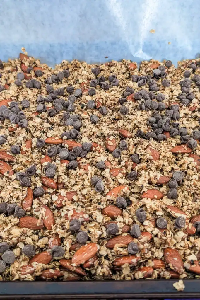 sprinkling the granola bar mixture with semi-sweet chocolate chips