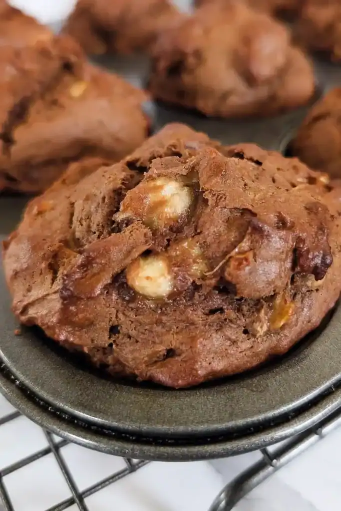 hunks of banana and walnut pieces in chocolate banana muffins