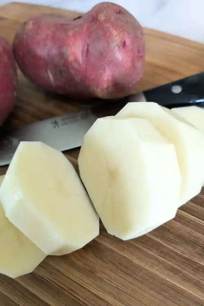 cut red potatoes in rounds-on cutting board with Henkels knife