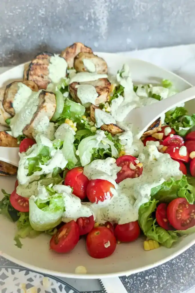 grilled potato corn summer salad with serving utensil on right of bowl