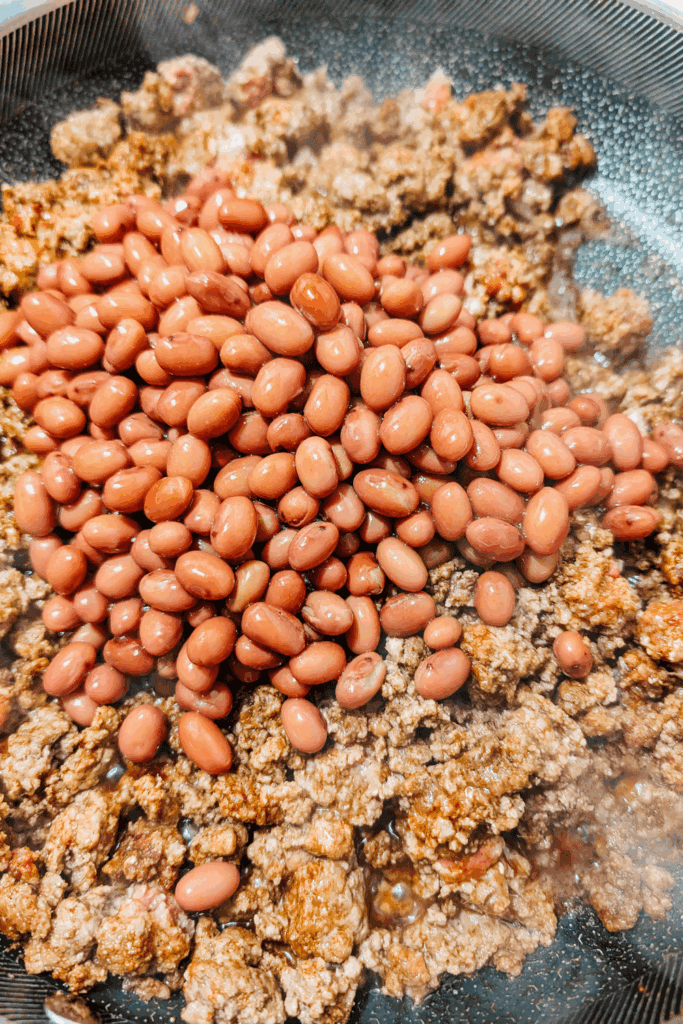 adding the kidney beans to ground beef for chili