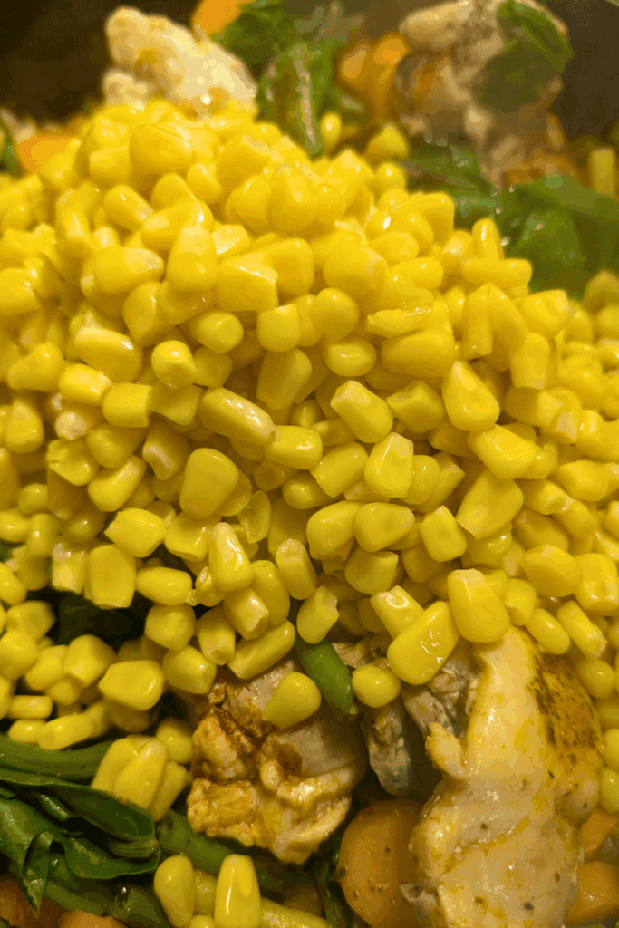 adding drained corn to dish