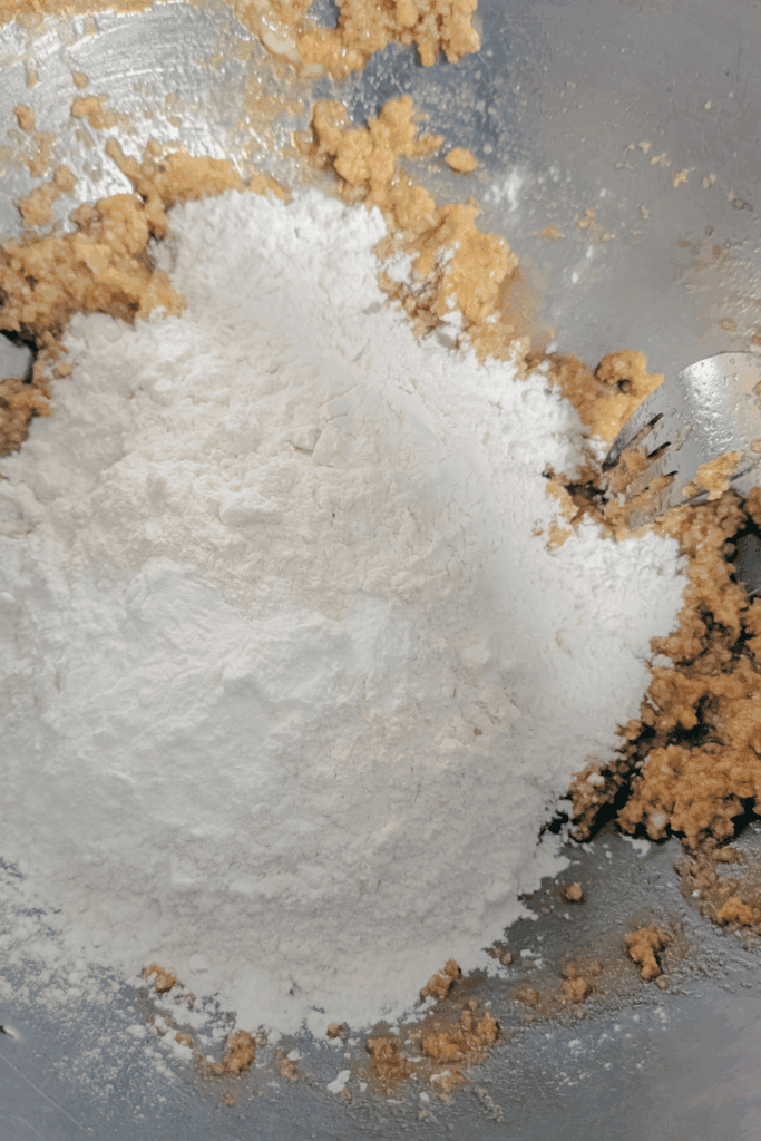 adding dry ingredients to creamed butter sugar mixture
