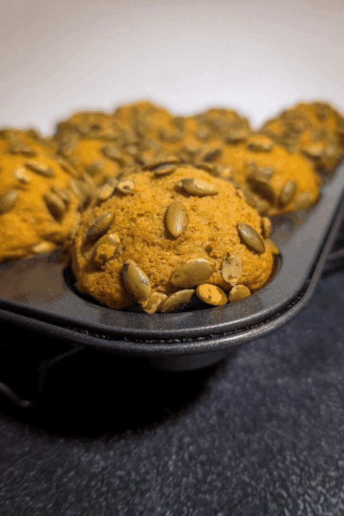 Grain-free pumpkin cookies with sunflower seeds on baking tray.