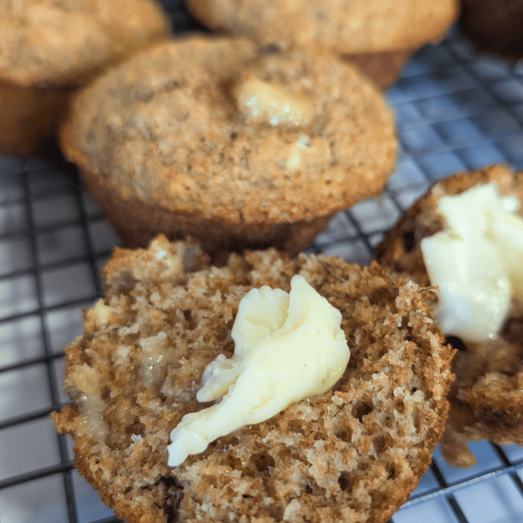 Freshly baked banana bran muffins topped with butter. Perfect for breakfast or a snack.