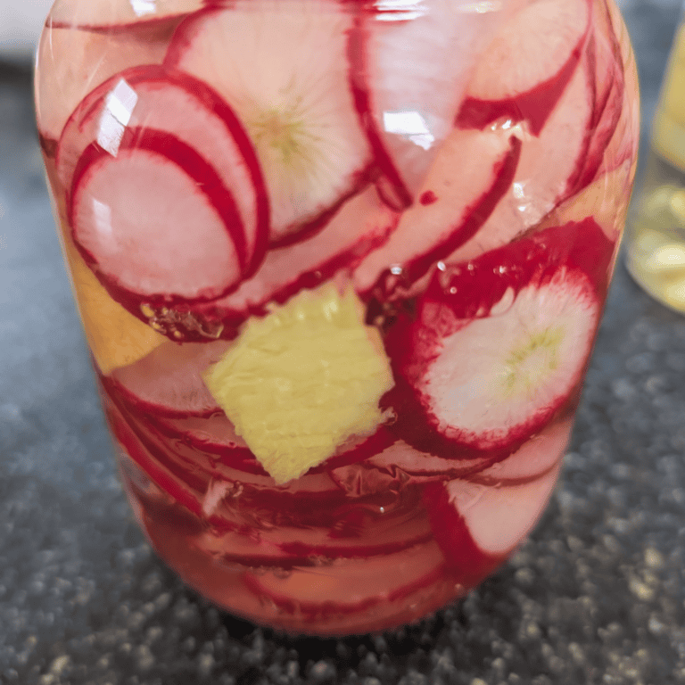 Freshly made pickled radishes with pineapple slices in a glass jar.