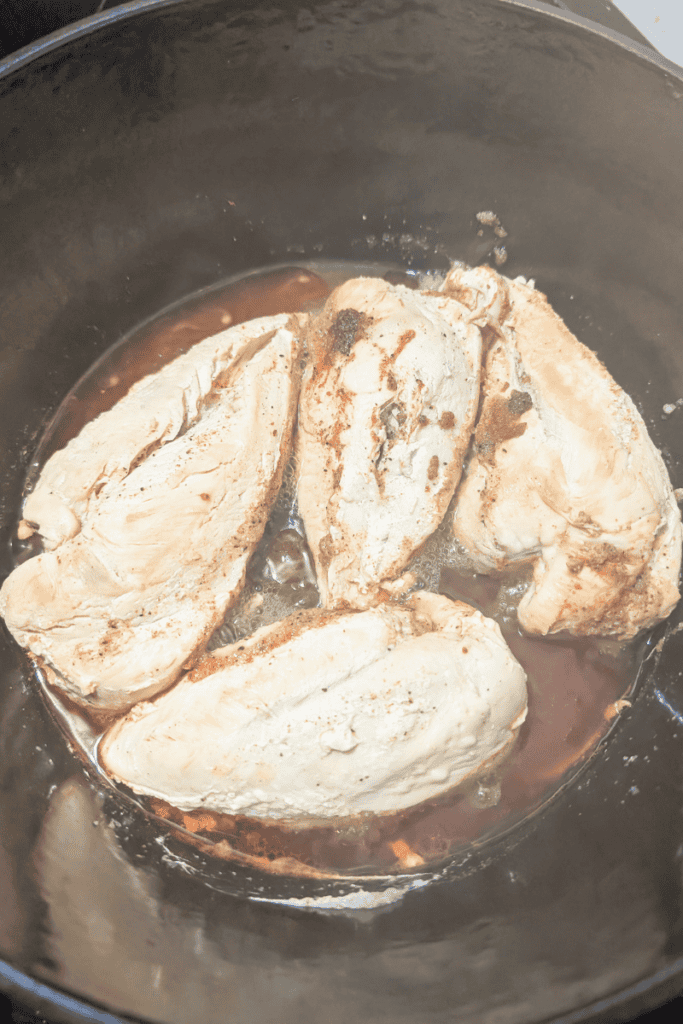 Shredded chicken breasts cooked in a Dutch oven, perfect for quick and healthy meal prep recipes.