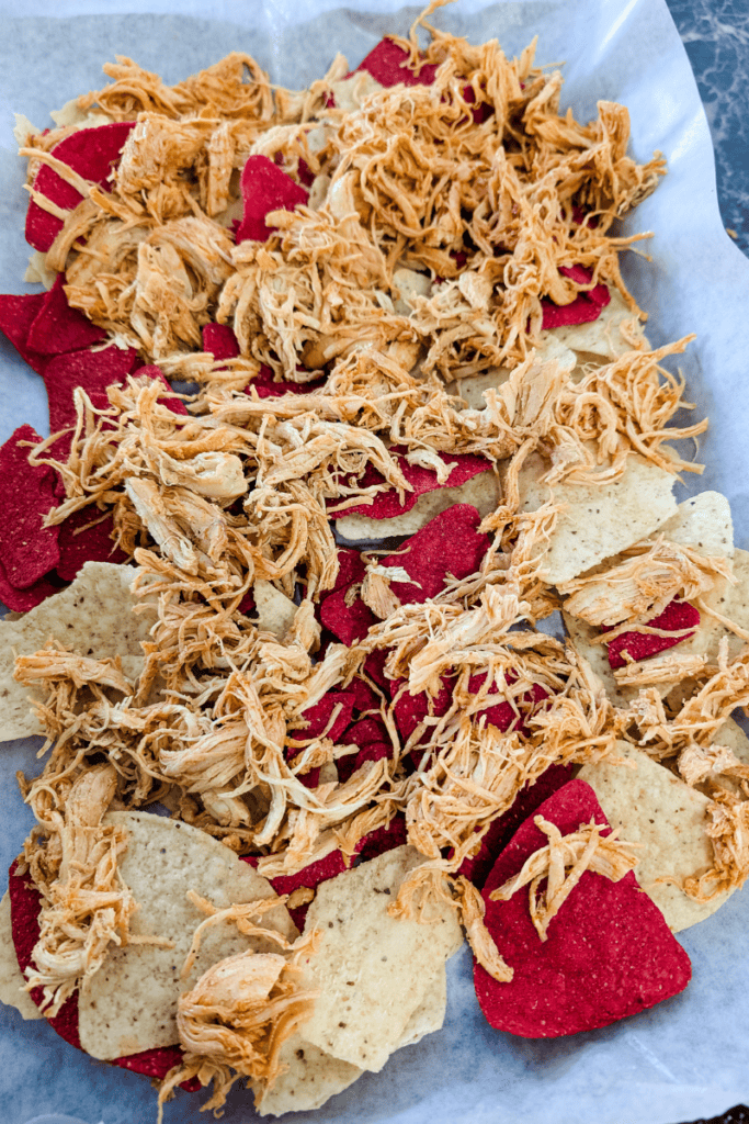 Shredded chicken breast on a bed of red potato chips, perfect for easy meal prep and quick recipes.