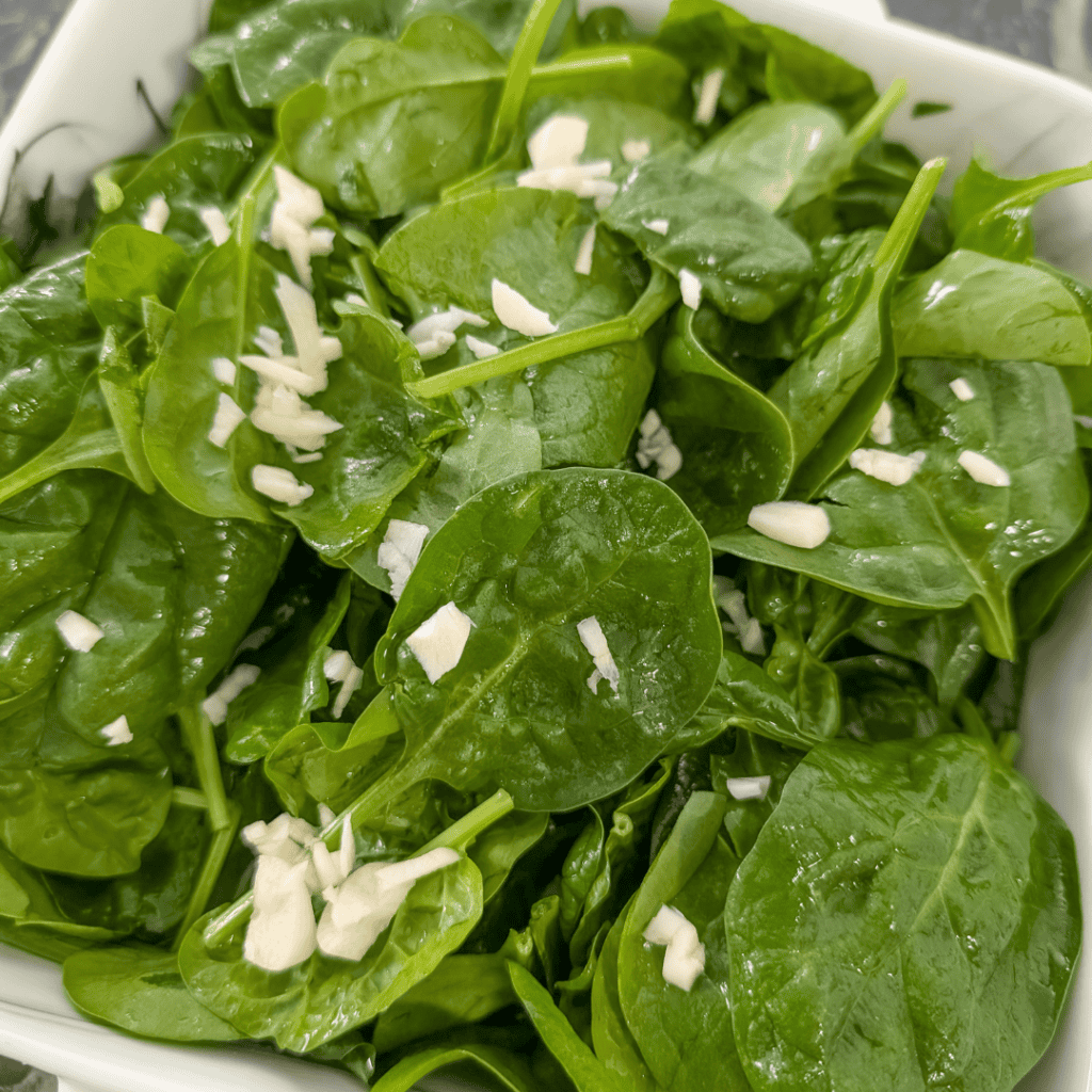 Fresh spinach leaves for spinach artichoke bake with feta and sun-dried tomatoes.