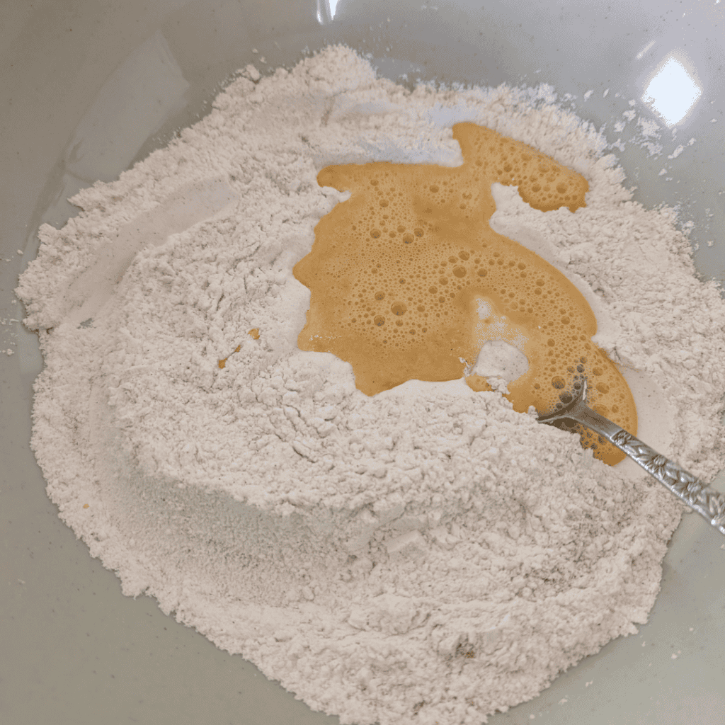Flour and beaten eggs in a mixing bowl for baking.