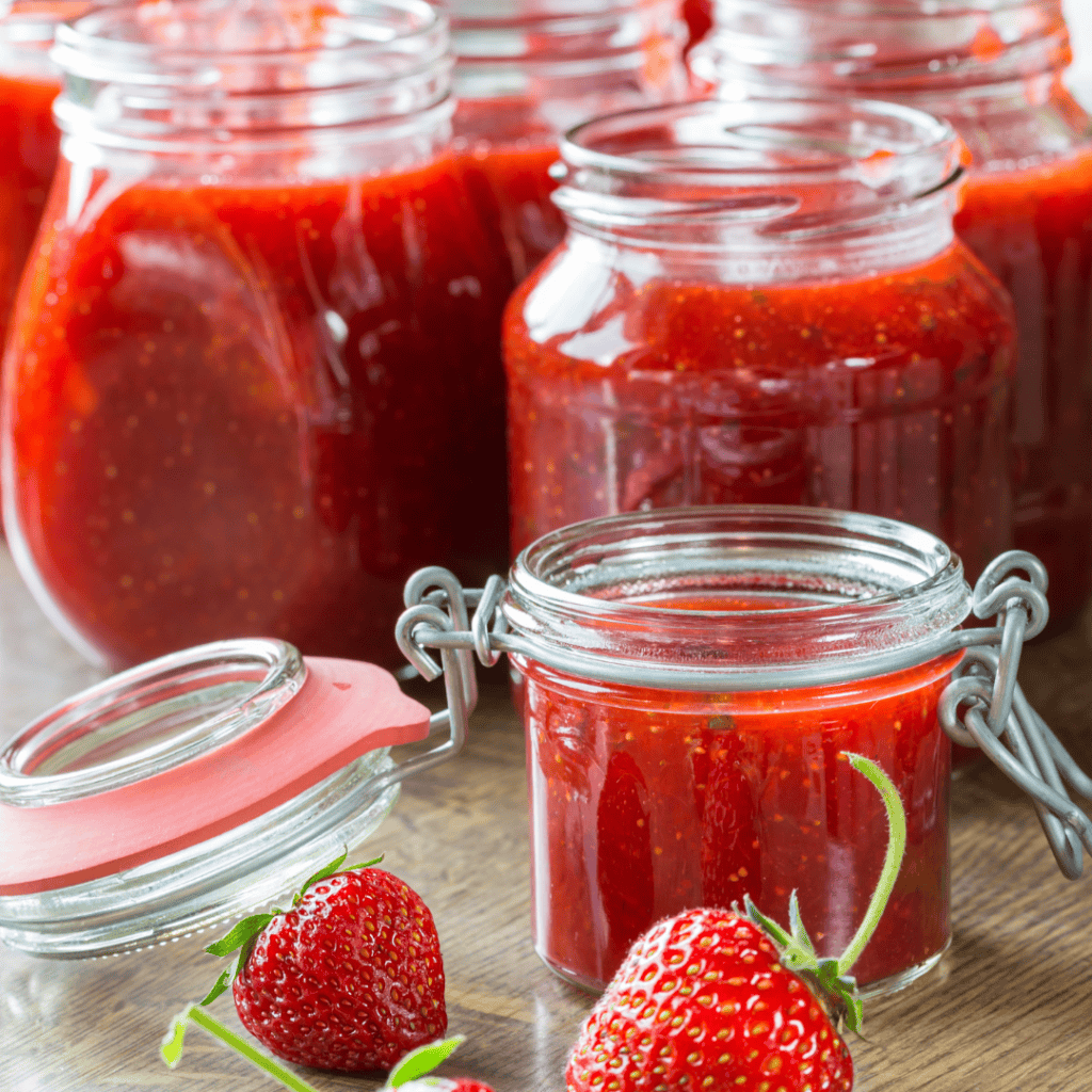Fresh homemade strawberry jam in glass jars, ready for spreading or gifting.