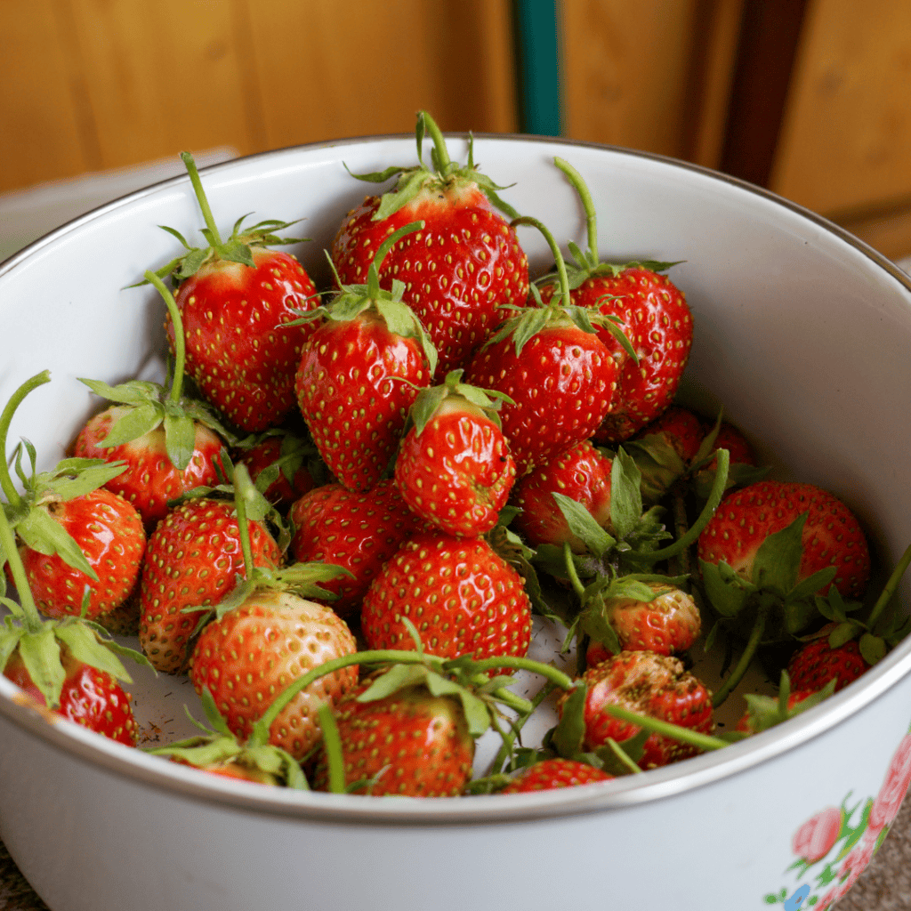 Fresh strawberries in a white bowl for healthy snacking.