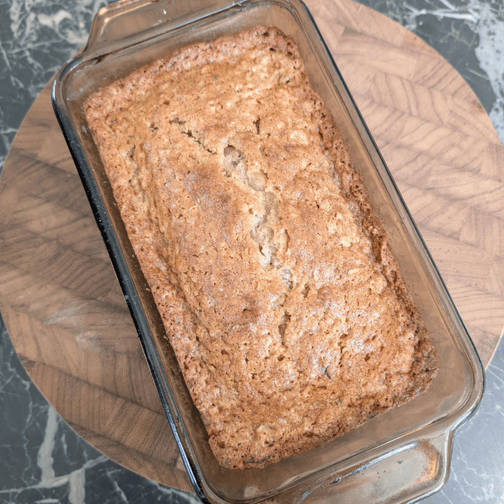 Freshly baked banana bread in a glass loaf pan, ready to enjoy.