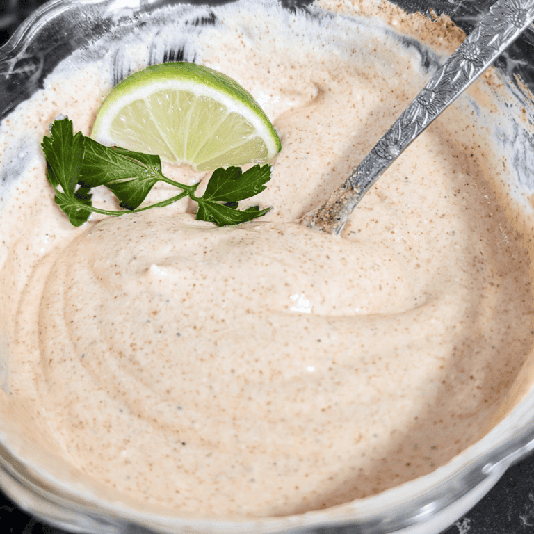 Creamy chipotle dressing with sour cream, lime, and herbs in a glass bowl.