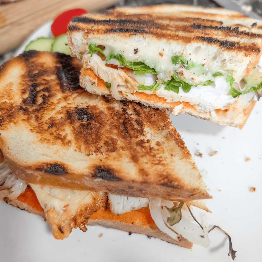 Delicious grilled chicken sandwich with lettuce, tomato, and melted cheese on toasted bread.