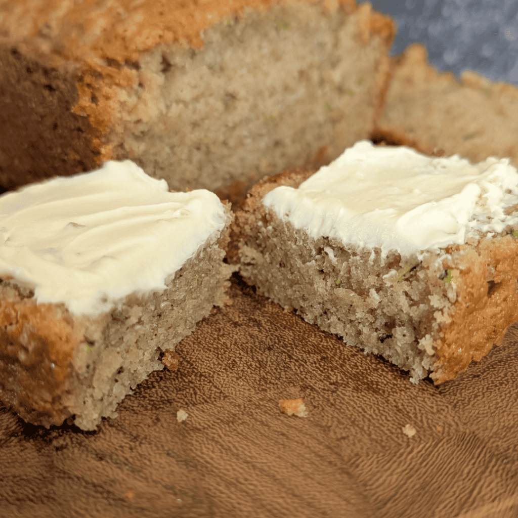 Fresh homemade zucchini bread with butter spread on top, close-up view.