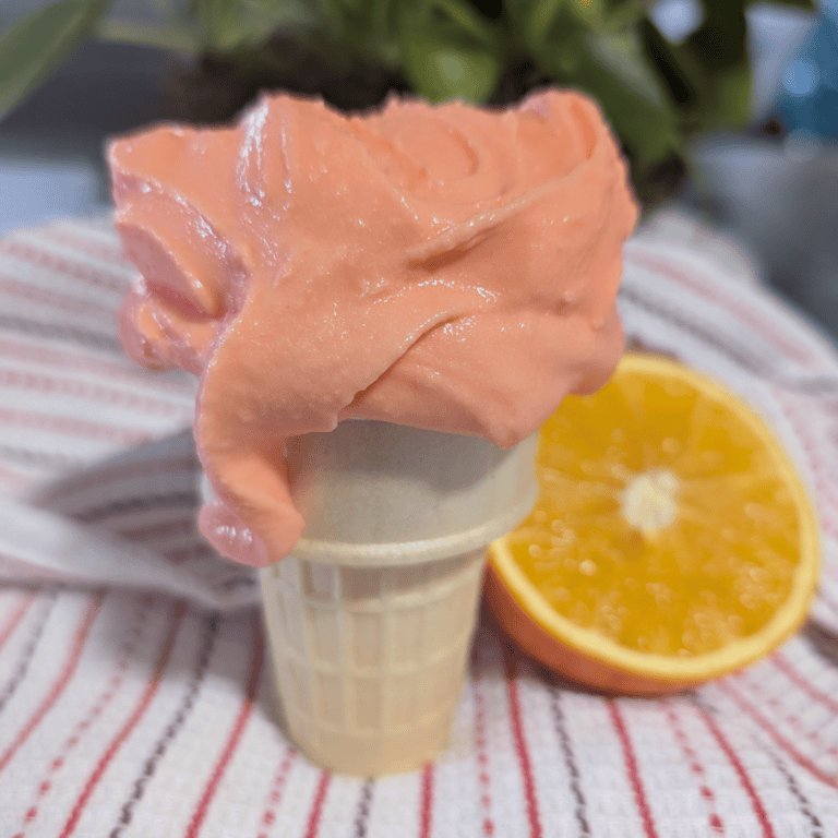 Delicious orange creamsicle Ninja Creami ice cream in a cone, perfect for summer treats and homemade.