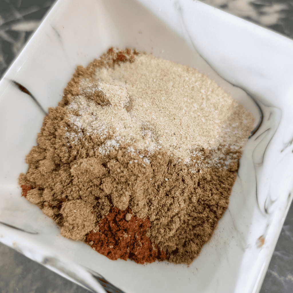 Seasoned ground beef with taco spices in a white bowl.