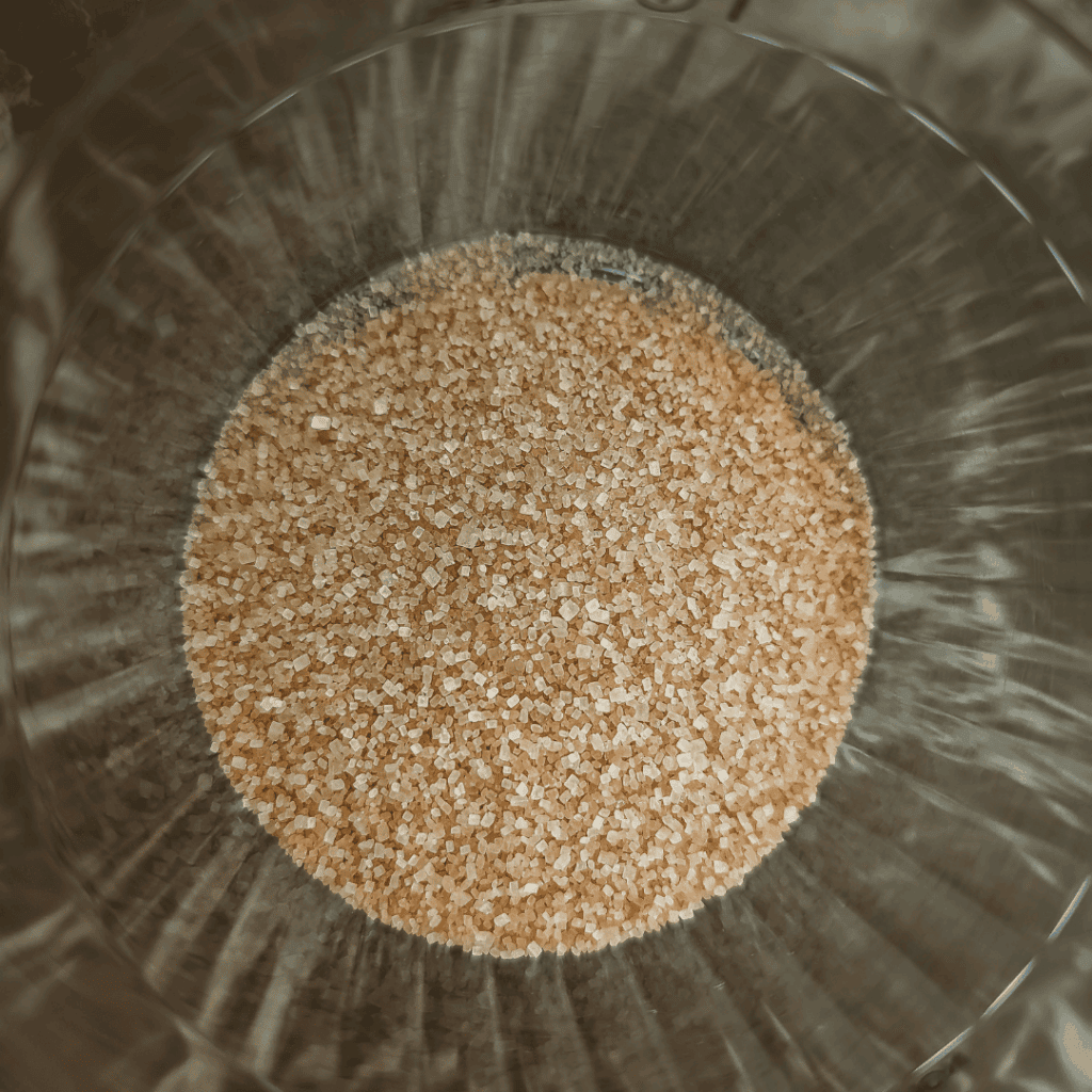 Brown sugar granules in a glass bowl, ideal for baking and cooking recipes.