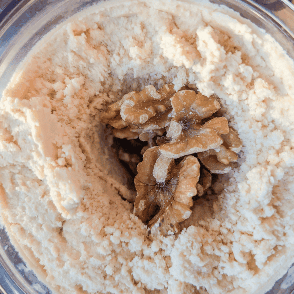 Close-up of walnut cookie dough with walnuts in the center.