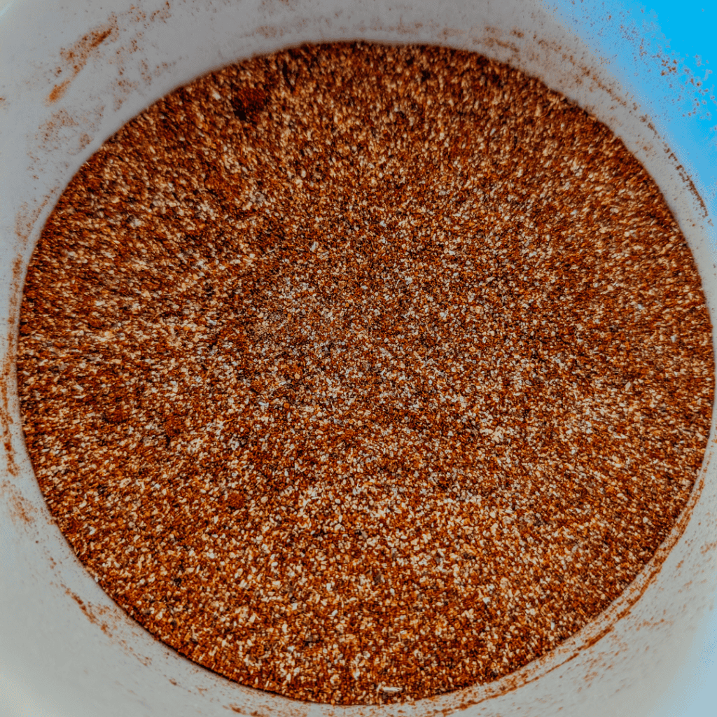 Close-up of a smoky spice rub in a bowl for BBQ chicken.