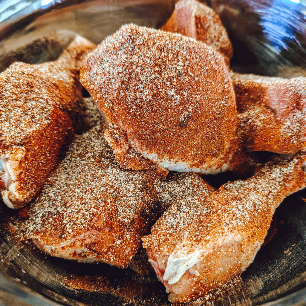 Close-up of seasoned BBQ chicken drumsticks with smoky spice rub.