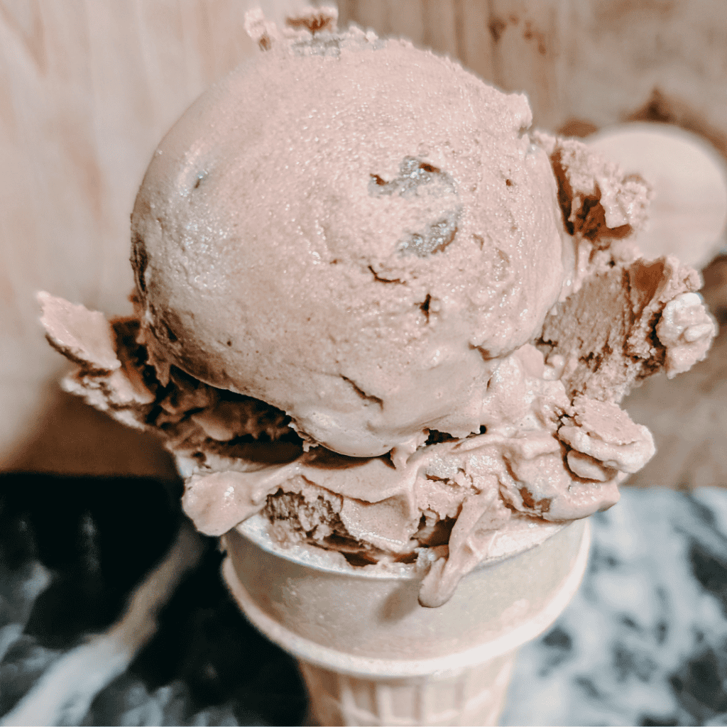 Delicious homemade chocolate ice cream served in a waffle cone, perfect for dessert lovers.