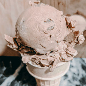 Delicious homemade chocolate ice cream served in a waffle cone, perfect for dessert lovers.