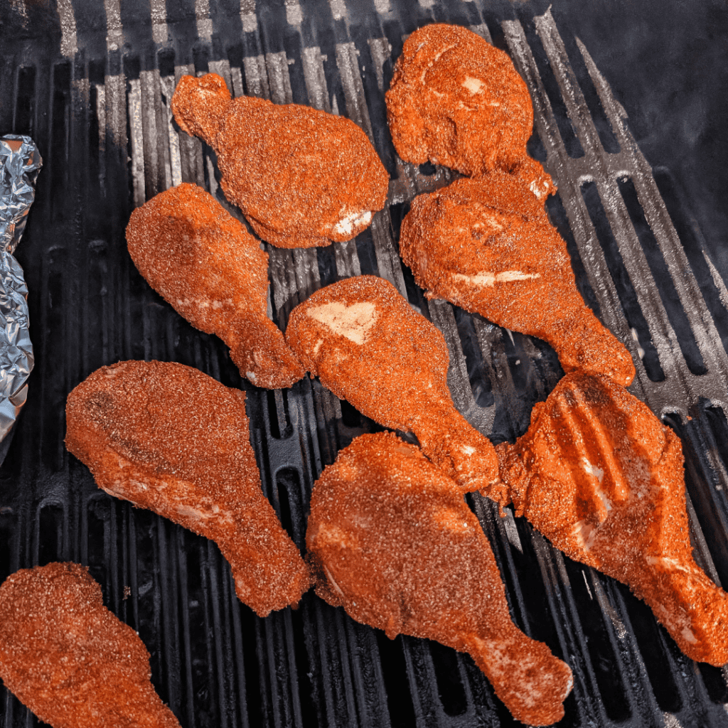 Close-up of crispy fried chicken drumsticks on grill rack.