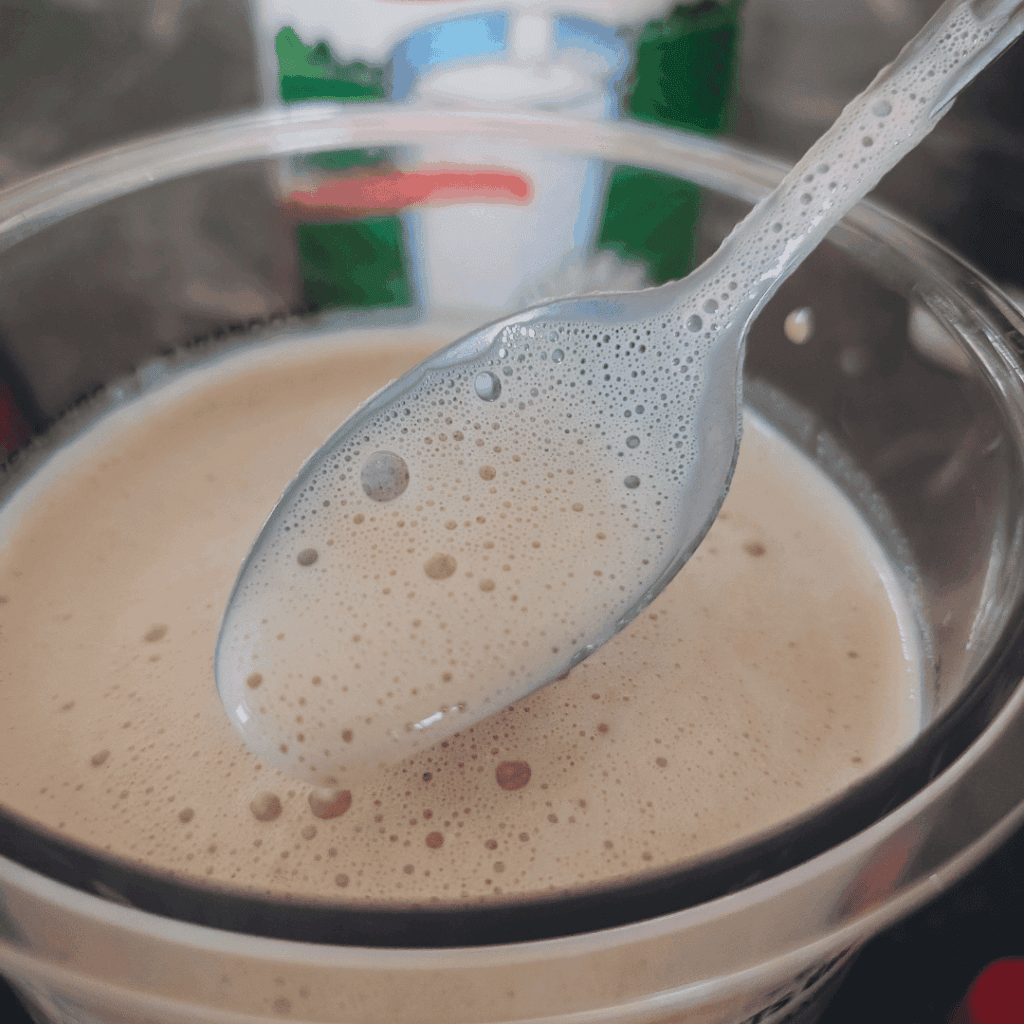 Creamy beverage in a glass with a spoon, close-up shot.