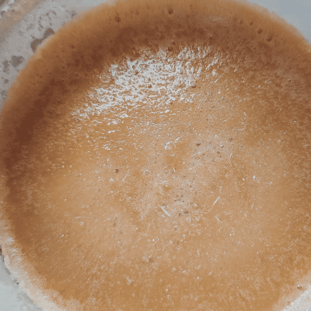 Close-up of coffee froth with creamy texture and bubbles.
