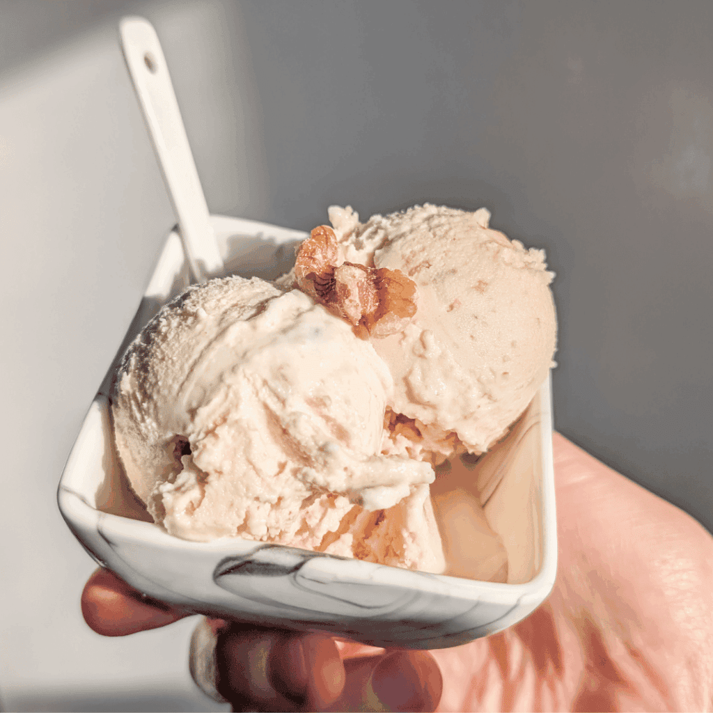 Creamy vanilla ice cream scoops served in a small bowl, perfect for dessert.
