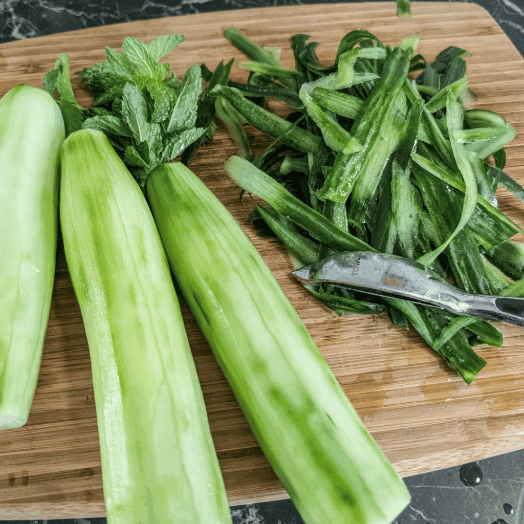Fresh celery stalks and chopped celery leaves on a wooden cutting board for healthy cooking.