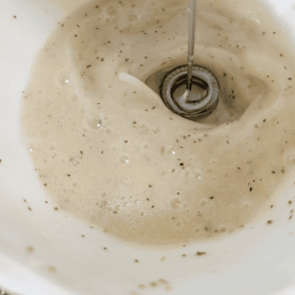 Blending creamy batter in a kitchen mixer for cooking or baking.