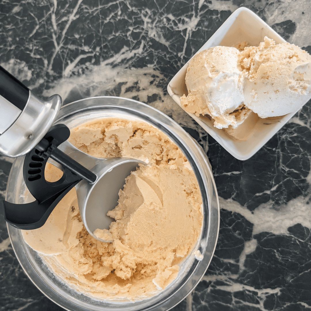 Creamy maple walnutcream in a bowl with an ice cream scoop, ready to serve.