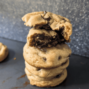 Stack of thick and soft chocolate chip cookies with melted chocolate.